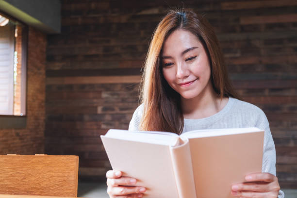 istock a beautiful young asian woman reading a book 1332456371