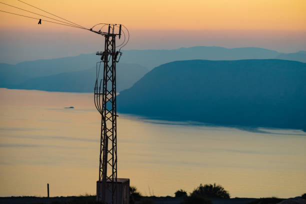 istock High voltage towers on coast at sunset 1332456659