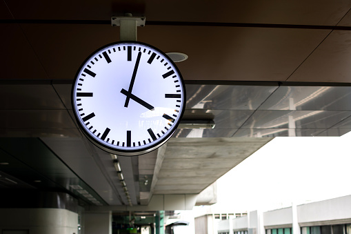 White clock in train station building.