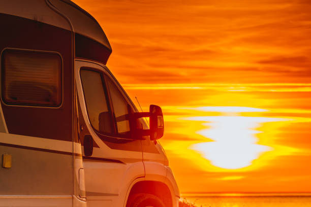 istock Camper vehicle on beach at sunrise 1332457612