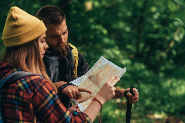 istock Hikers using trekking poles and a map while walking in the nature 1332457856