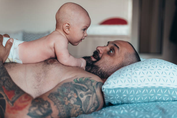 istock Tattooed bearded father playing with his son 1332457888