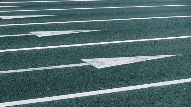 istock Directional arrows on asphalt, toned in blue 1332460860