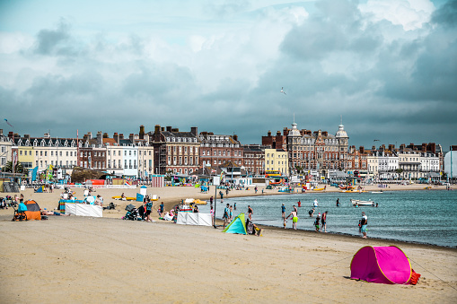 Tents And Tourists Settling On Weymouth Beach, UK