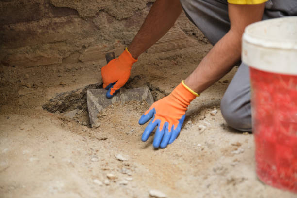istock Unrecognizable young builder shoveling sand at a construction site. 1332461823