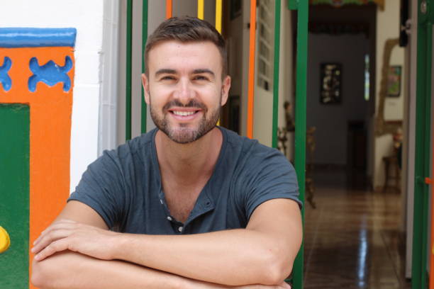 istock Good looking young man smiling in front of home 1332462845