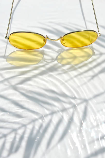 istock yellow sunglasses under a palm tree on a white water background 1332467194