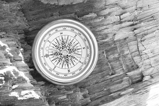 round compass on wooden background as symbol of tourism with compass, travel with compass and outdoor activities with compass