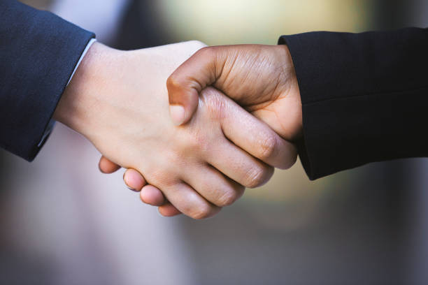istock Closeup image of two women shaking hands 1332468854