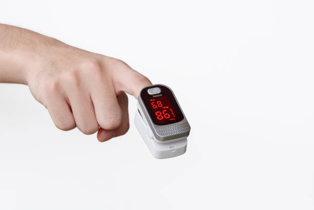 focus at pulse oximeter on index finger of young man hand on isolated white background - taking pulse oximeter medical oxygen equipment human lung imagens e fotografias de stock