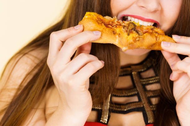 istock Woman eating hot pizza slice 1332473155
