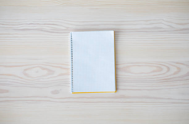 istock Empty white spiral notepad as mockup for your design on wooden table background, top view, free space 1332475211