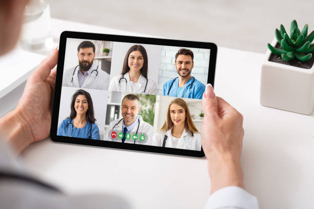 istock Physician Making Group Video Call With Colleagues Using Tablet Indoor 1332475315