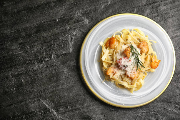istock Delicious pasta with shrimps on black table, top view. Space for text 1332476545
