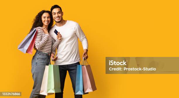 Easy Shopping Happy Arab Couple Holding Credit Card And Bright Shopper Bags Stock Photo - Download Image Now