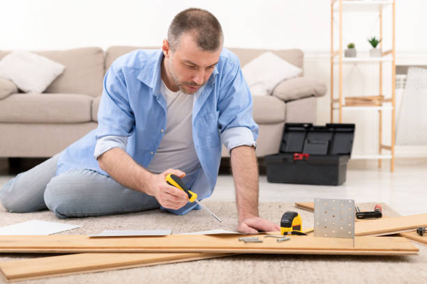istock Middle-Aged Man Installing Furniture Reading Self-Assembly Manual At Home 1332476883