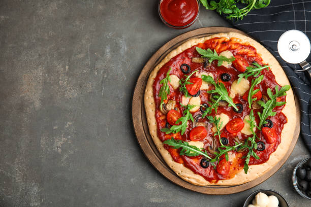istock Pita pizza with cheese, olives, tomatoes and arugula on grey table, flat lay. Space for text 1332478074