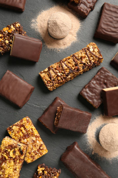 istock Different tasty energy bars and protein powder on black table, flat lay 1332478091