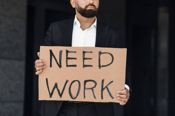 istock Need work. Unrecognizable male office worker holding cardboard sign, standing outdoors near business center, crop 1332478121