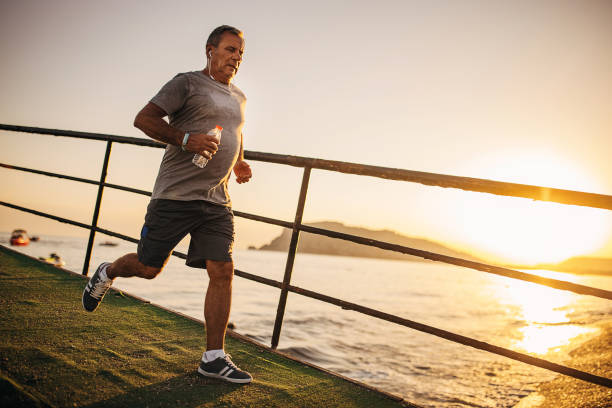 istock Senior man jogging by the sea 1332478187