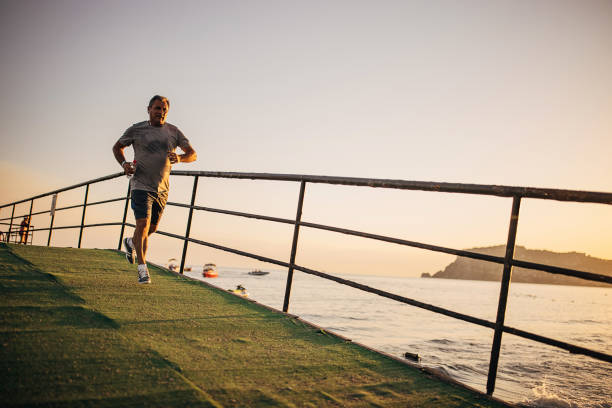 istock Senior man jogging by the sea 1332478253