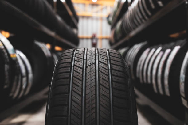 un nuovo pneumatico viene posizionato sul portapacchi nell'officina automobilistica. preparati per i veicoli che devono cambiare pneumatici. - rubber foto e immagini stock