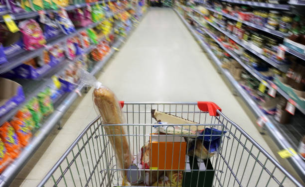Person pushing shopping cart rushing in supermarket stock photo