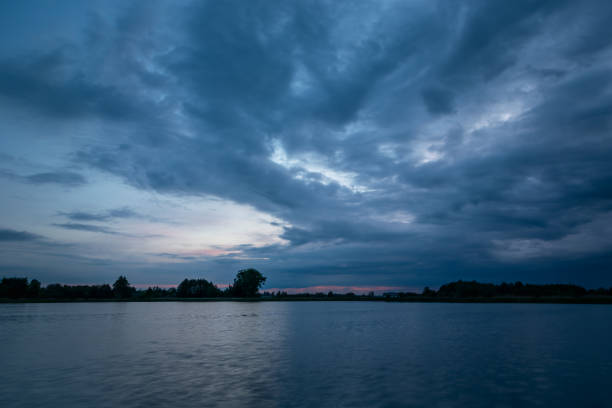 istock Cloudy evening sky over a calm lake 1332480750