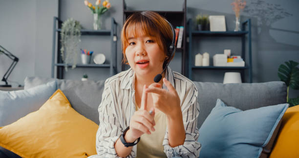 istock Asia businesswoman using laptop talk to colleagues about plan in video call while working from house at living room. 1332482128