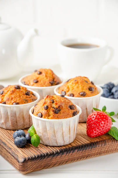 istock Muffins with chocolate chips on a wooden bord on a white background with fresh berries. Copy space. 1332483542
