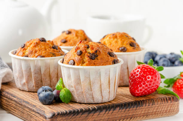 istock Muffins with chocolate chips on a wooden bord on a white background with fresh berries. Copy space. 1332483606