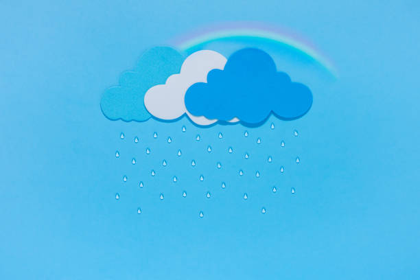 istock Rainbow after the rain. Cut paper clouds, raindrops and rainbows on a blue background. 1332484010