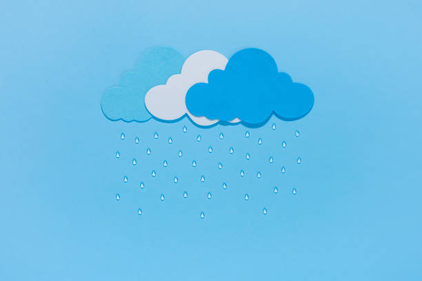 istock Paper cut clouds with rain drops on blue background. 1332484064