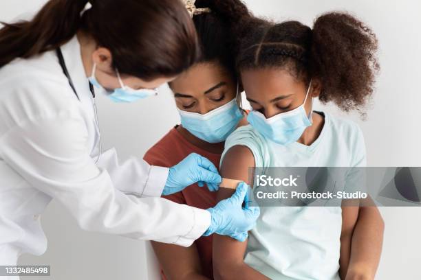 African American Family Making Vaccination At Hospital Wearing Face Masks Stock Photo - Download Image Now