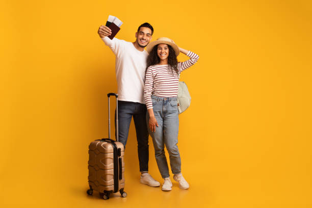 vacances enfin. portrait d’un heureux couple de touristes arabes avec passeports et valises - travel passport suitcase journey photos et images de collection