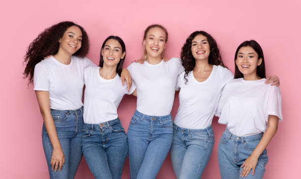 istock Five Smiling Mixed Young Women Embracing Standing Over Pink Background 1332489698