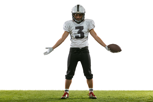 Losing game, match. Portrait of American football player training isolated on white studio background with green grass. Concept of sport, movement, achievements. Copy space for ad. Looks upset