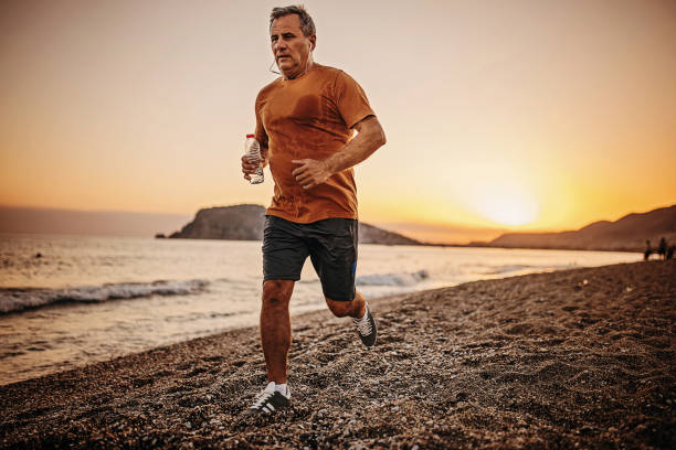 istock Man jogging by the sea in sunset 1332491458