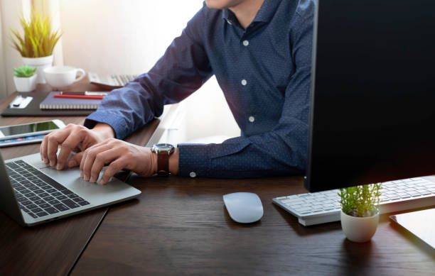 istock image of man hand using and typing keyboard of laptop computer on office desk. 1332492275