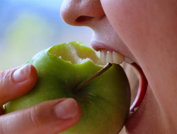 mordere una mela - foto d'archivio - apple women green eating foto e immagini stock