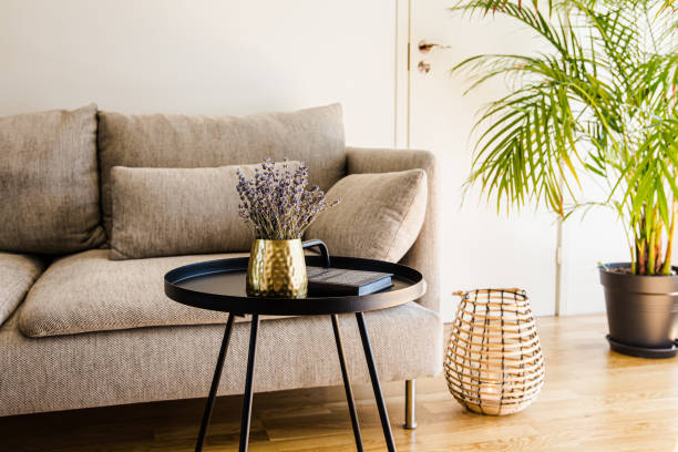 minimalista moderno soggiorno casa tavolo accento nero con vaso color oro e libro tavolo in metallo nero su pavimento in legno di rovere naturale. - side table foto e immagini stock