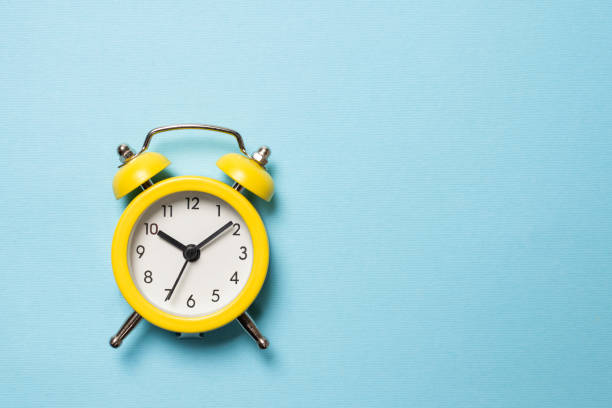 istock Yellow alarm clock on a blue background. Copy space. 1332505833