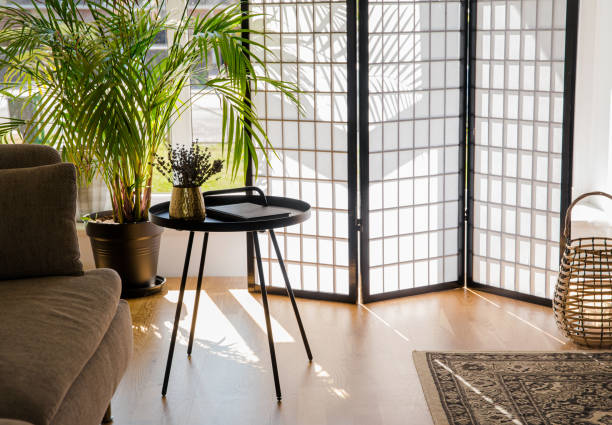 sala de estar en casa con pantalla divisora de madera y papel que bloquea el sol de la ventana, mesa de acento de metal negro y sofá, colores naturales. - biombo fotografías e imágenes de stock