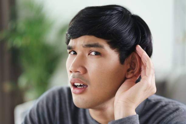 istock Young Asian deaf disabled man having hearing problems holds his hand over the ear, listens carefully, hard of hearing. 1332509745