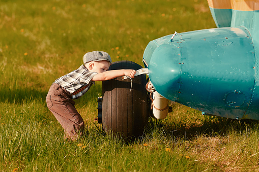 A little boy is curious about the design of the plane. The concept of choosing a future profession.