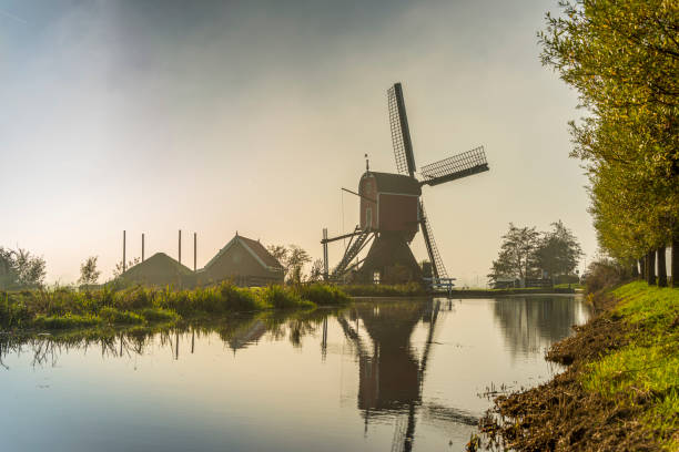 голландск�ая сцена с туманом и ветряной мельницей, восход солнца - polder windmill space landscape стоковые фото и изображения