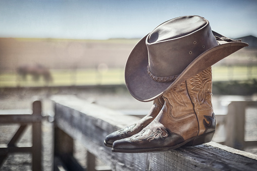 Country music festival live concert with cowboy hat and boots by ranch stables