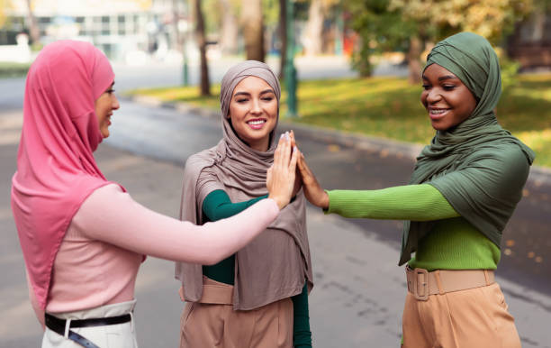 istock Three Diverse Islamic Women Giving High-Five Standing Outside, Wearing Hijab 1332517672