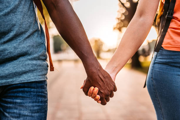 istock Couple holding hands while walking in the street 1332518113