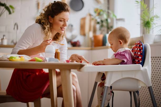 istock Mother feeding baby in the kitchen 1332520282